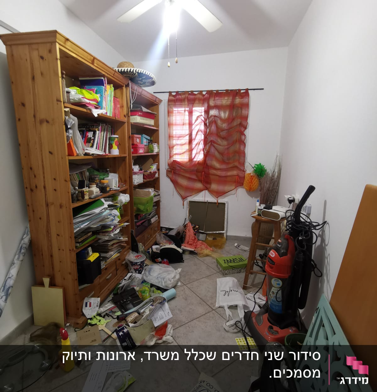 חדר מבולגן עם מדפים, שואב אבק וחפצים מפוזרים על הרצפה.